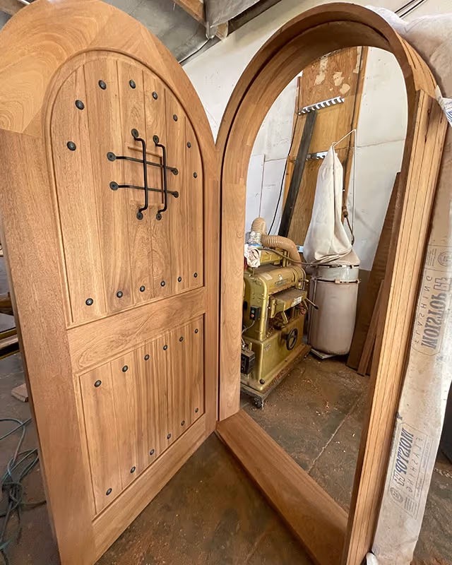 Bespoke Spanish Colonial arched entry door with speakeasy grille built for a Los Feliz home
